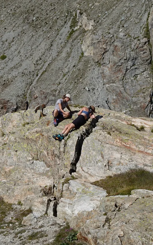 Friends sitting by a crack in the mountainside